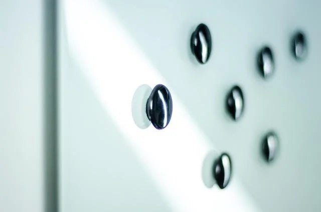 Black disc magnets on glass whiteboard